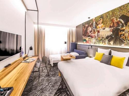 弗罗茨瓦夫弗罗茨瓦夫市中心美居酒店的酒店客房设有一张大床和一张书桌。