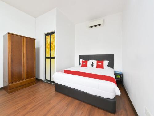 雪邦OYO 90869 Hotel Madeena Inn的一间卧室配有一张带红色枕头的大床