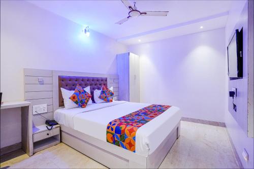 孟买FabExpress Embassy Suites的白色卧室配有一张带彩色枕头的大床