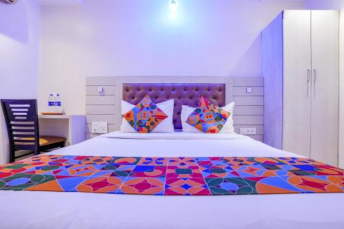 孟买FabExpress Embassy Suites的一间卧室配有一张带五颜六色被子的床