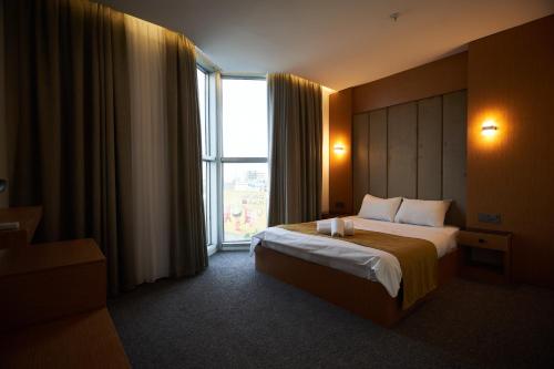 埃尔比勒MyHotel Erbil的酒店客房设有一张床和一个大窗户