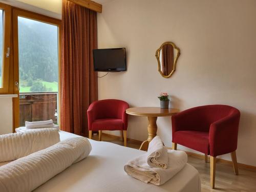 施图拜河谷新施蒂夫特Pension Terra的酒店客房配有一张床、两把椅子和一张桌子