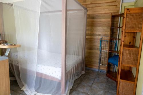 圣克洛德L’émeraude的一间卧室配有一张带蚊帐的床