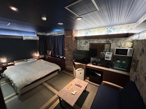 京都Hotel Sunday Brunch (Adult Only)的一间卧室配有一张床和一张书桌及电视