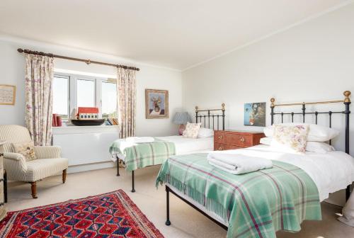 南安普敦Gins Barn的一间卧室配有两张床和椅子