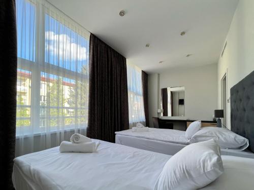 里马夫斯卡索博塔AM HOTEL WELLNESS ****的一间卧室设有两张床和大窗户