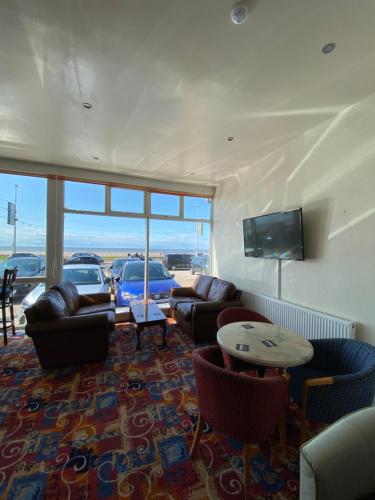 布莱克浦South Beach Hotel的客厅配有沙发、椅子和平面电视。