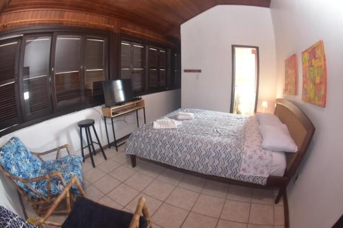 尚格里拉Pousada Quintal !的一间卧室配有一张床、一张书桌和一台电视。