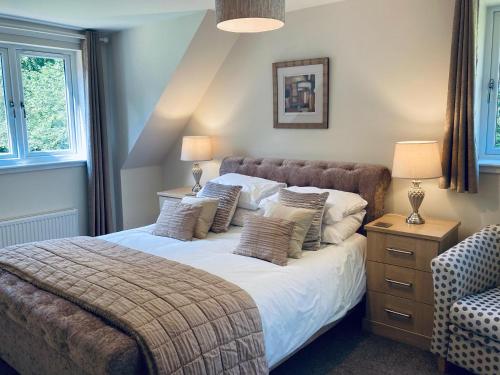 爱丁堡Estate Houses at Carberry Tower的一间卧室配有一张大床、两盏灯和一把椅子