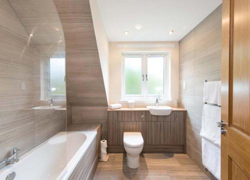 爱丁堡Estate Houses at Carberry Tower的带浴缸、卫生间和盥洗盆的浴室