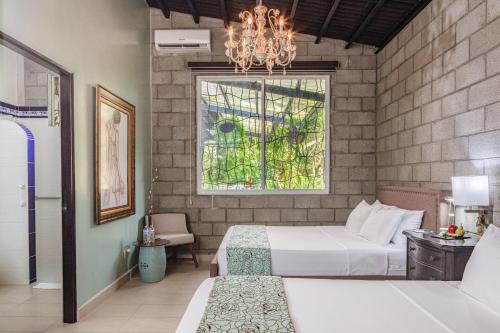 埃尔巴列德安通Casa Madre Tierra的一间卧室设有两张床、一个窗户和一个吊灯。