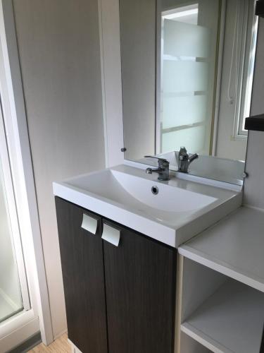 乌尔加特Mobil home 6 personnes dans camping 5*的浴室设有白色水槽和镜子