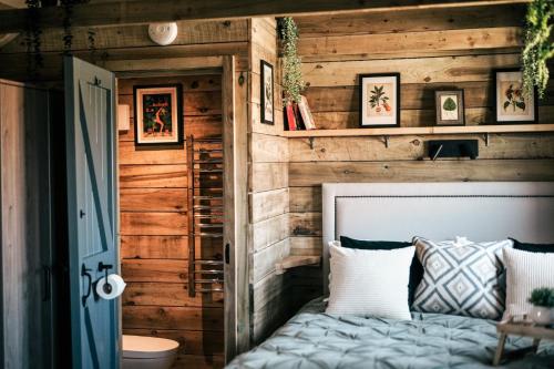 Saint ErvanThe Potting Barn的一间卧室设有木墙和床