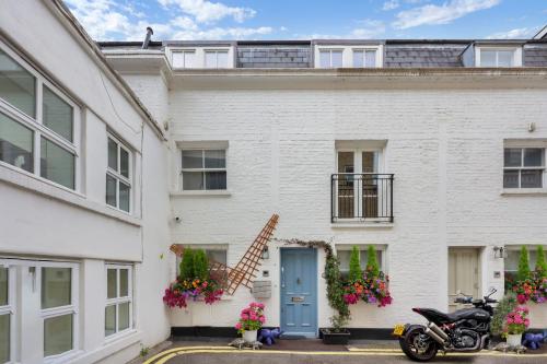 伦敦Luxury 3 Bed House by Hyde Park, Bayswater的一辆停在前面的摩托车白色房子