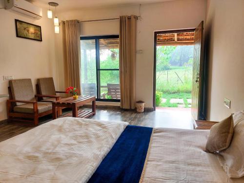 塔拉Grand Narmada Homestay Resort-Bandhavgarh的一间卧室配有一张床、一张桌子和一个窗户。