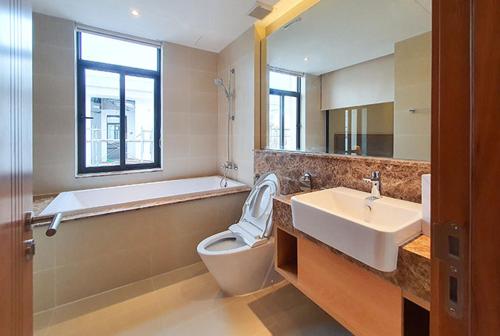 芽庄Luxury villa trong Whyndham garden Cam Ranh的带浴缸、卫生间和盥洗盆的浴室