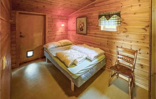 SvullryaGorgeous Home In Grue Finnskog With House A Panoramic View的小木屋内一间卧室,配有一张床和一把椅子