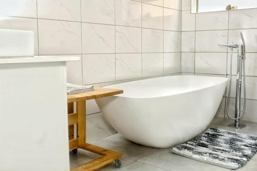内尔斯普雷特Mills Pad with 2-bedroom的浴室配有白色浴缸及桌子