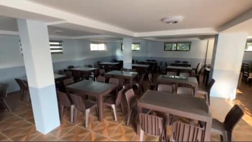 圣安东尼奥Playa Alba Beach Front and Resort的一间在房间内配有桌椅的餐厅