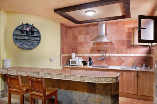 亚伊萨Casa Barriguita的厨房配有带椅子的柜台和微波炉