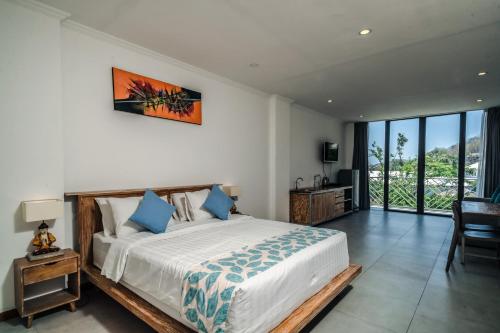 纳闽巴霍Komodo Suites Downtown Managed by CPM Bali的一间卧室配有一张带蓝色枕头的大床