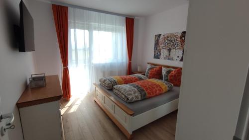 锡比乌Apartment Joerg Sibiu的卧室配有带枕头的床铺和窗户。