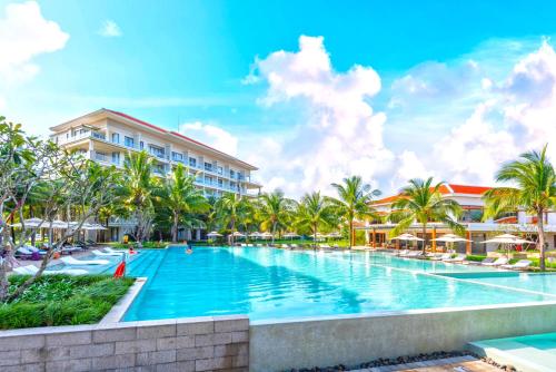 岘港Danang Amazing Ocean Villas的棕榈树度假村的游泳池