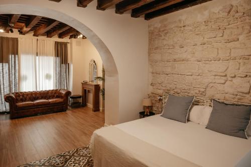 赫雷斯-德拉弗龙特拉Astuto Boutique Jerez - Adults Only的一间卧室设有一张床和石墙