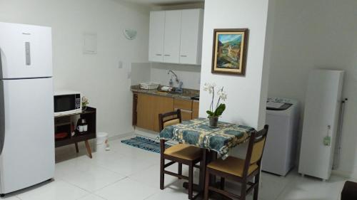 莫日-达斯克鲁济斯Apartamento Completo A25 Flat Centro的一间带桌子和冰箱的小厨房