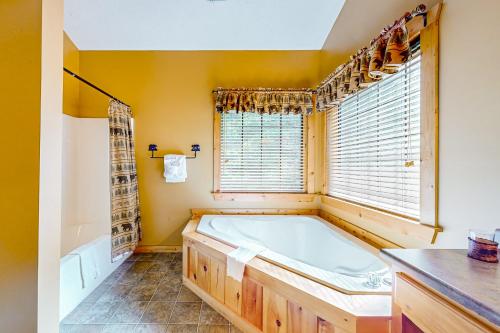 加特林堡Cozy Cub Cabin的带浴缸和窗户的大浴室