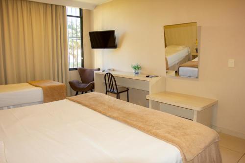 巴西利亚大使酒店的酒店客房带一张床、一张书桌和一面镜子