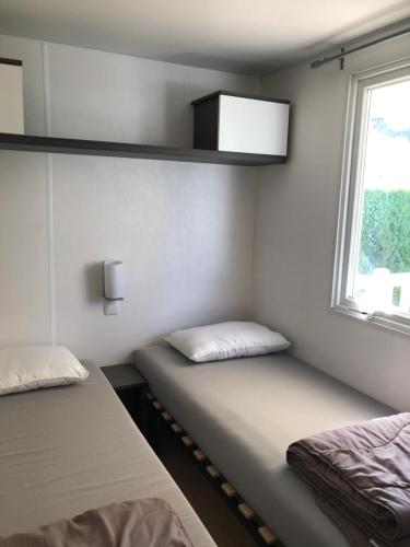 乌尔加特Mobil home 6 personnes dans camping 5*的小型客房 - 带2张床和窗户