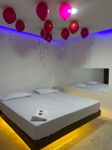 BaranoaMOTEL SANTORINI的一间设有一张从天花板上悬挂着气球的床的房间