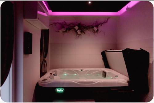 勒米尔蒙spa de la quarterelle LOVE ROOM 88 VOSGES的带浴缸的浴室,配有紫色照明