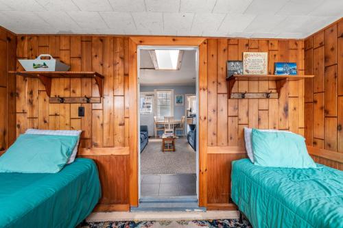海洋海滩The Blue Parrot Cottage的木墙客房的两张床