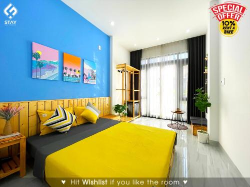 岘港FSTAY - COZY AND PEACEFUL HOMESTAY DA NANG的一间卧室设有黄色的床和蓝色的墙壁
