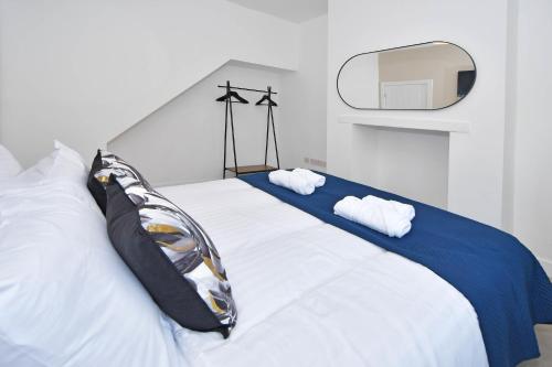 克鲁Unity House - A Stylish Haven with 3 Bedrooms, Perfect for Your Tranquil Getaway的一张带两个枕头和镜子的白色床