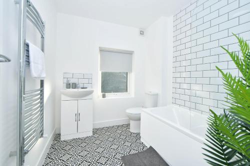 克鲁Unity House - A Stylish Haven with 3 Bedrooms, Perfect for Your Tranquil Getaway的带浴缸、卫生间和盥洗盆的浴室