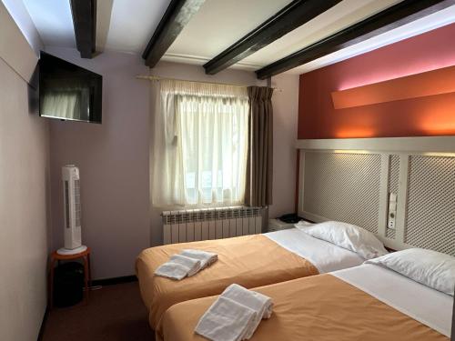 阿林萨尔Hotel Micolau的酒店客房设有两张床和电视。