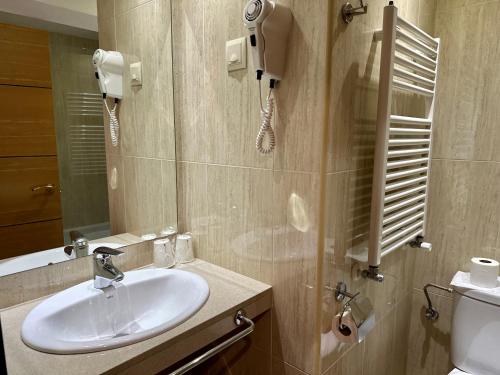 阿林萨尔Hotel Micolau的一间带水槽、镜子和卫生间的浴室