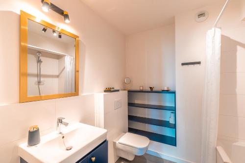 克拉科夫Apartament Chmielna Gold的一间带水槽、卫生间和镜子的浴室