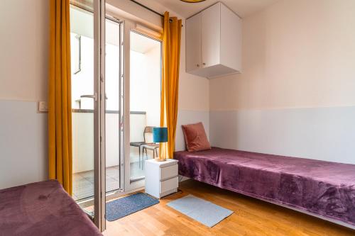 克拉科夫Apartament Chmielna Gold的客房设有紫色的床和窗户。