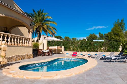 莫莱拉Villa Llobell - Plusholidays的一个带椅子和桌子的庭院内的游泳池