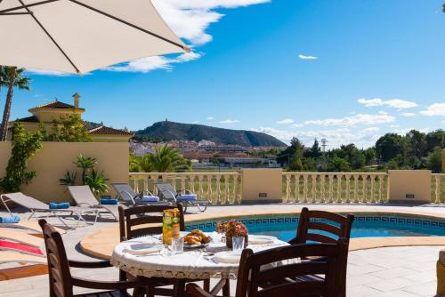 莫莱拉Villa Llobell - Plusholidays的一个带桌椅的庭院和一个游泳池