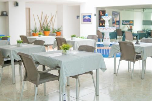 伊瓦格HOTEL VERANO的一间设有白色桌椅的用餐室