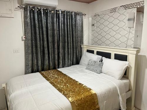 乔治敦Odyssey Suites Loft Apartment的一间卧室配有一张带黑色和金色床头板的床