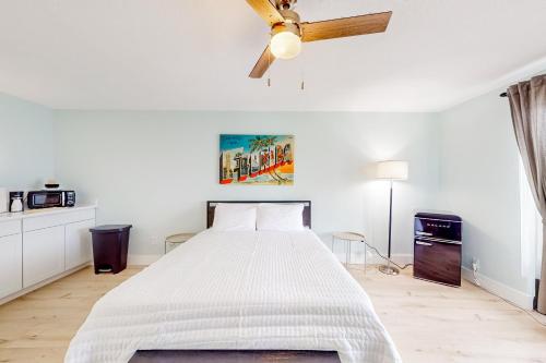 马可岛Capri 103的白色卧室配有床和吊扇