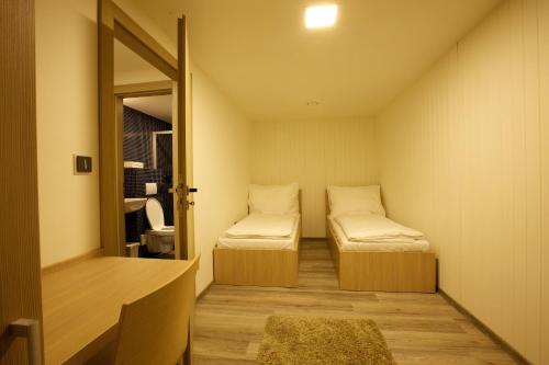 Svojetice斯沃耶蒂采御马俱乐部酒店的小房间设有两张床和镜子
