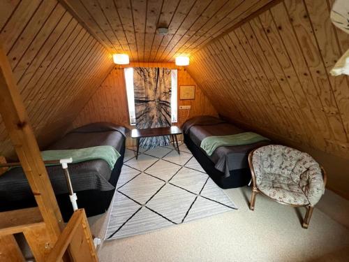 基蒂莱Adorable 1-bedroom cottage/guesthouse in Kittilä的阁楼间 - 带2张床和椅子