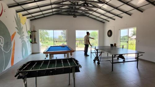 Haasienda - Nido del Colibri - Casa de Arbol的站在一个有两张乒乓球桌的房间的人